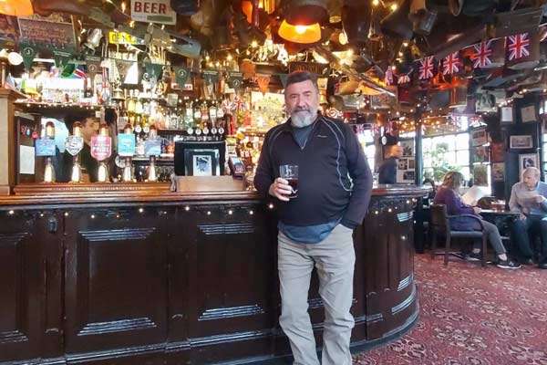 Tim enjoying a cold beer in the cozy interior of The Churchill Arms